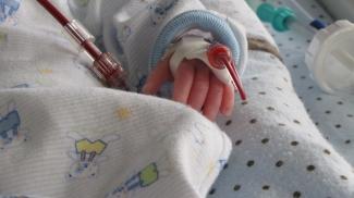 Image of a baby in the hospital bed performing a blood transfusion