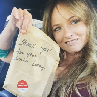 woman showing thank you note for donating plasma