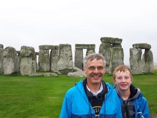 Dr. Blake and his son posing with the UK Stonehenge behind them