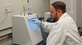 Research associate pointing to a screen in a lab
