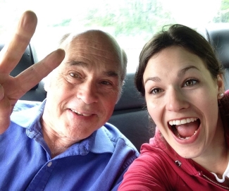 Man giving piece sign with daughter next to him