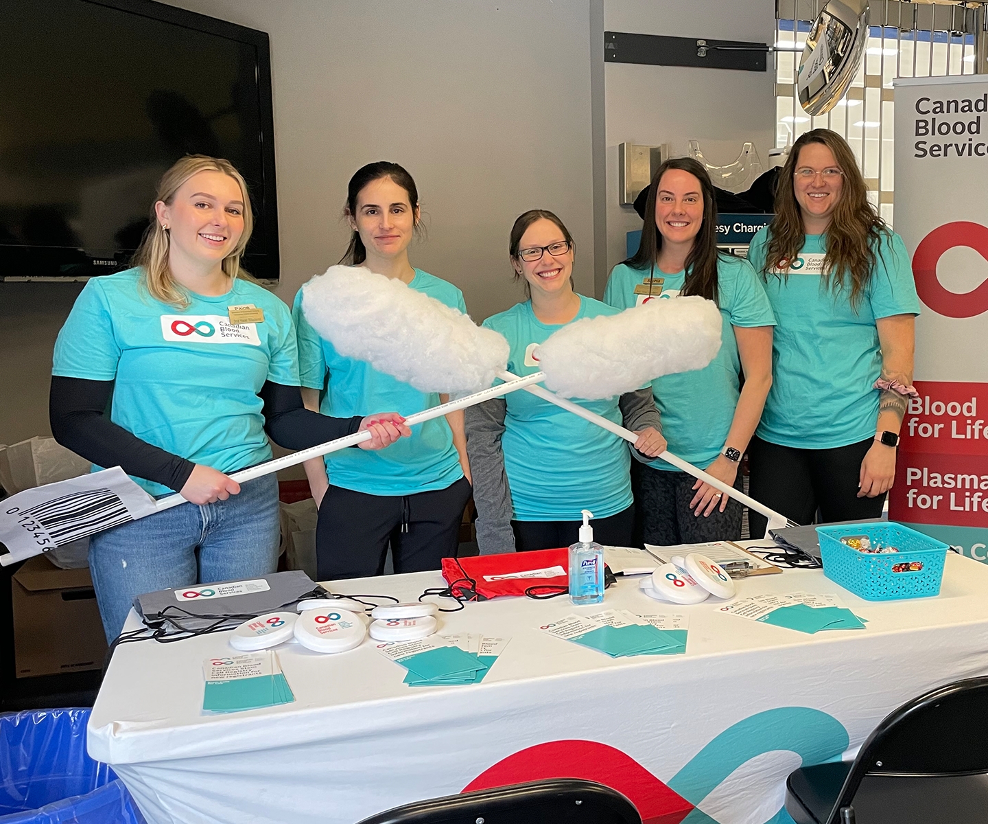 Group of students holding two giant swabs 