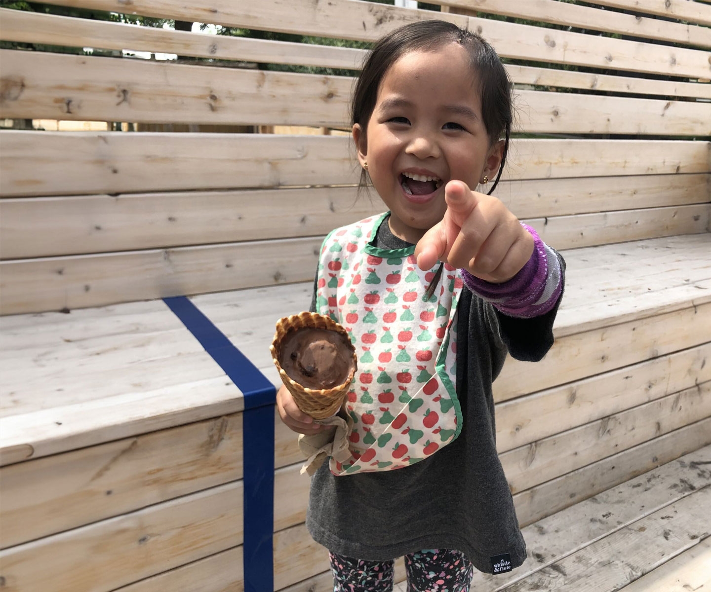  Child blood recipient holding ice cream, smiling and pointing at photographer