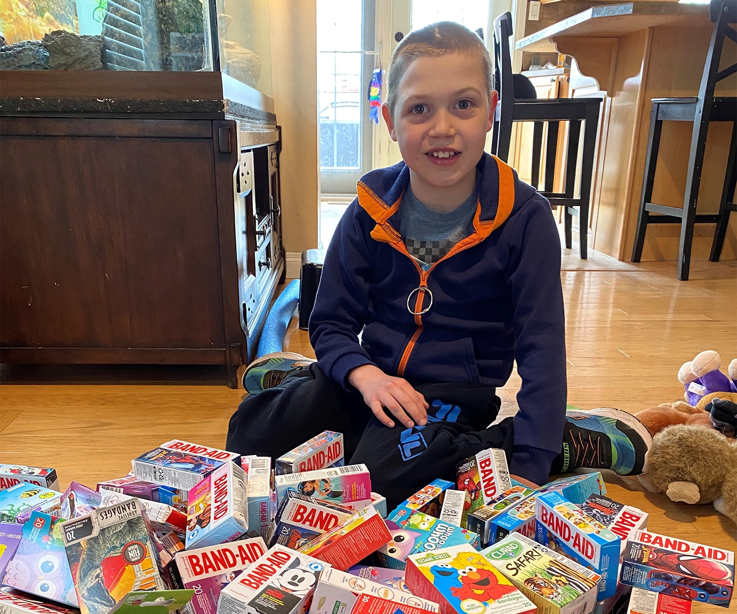 Blood recipient, Elias Martin, sits surrounded by boxes of Band-Aids