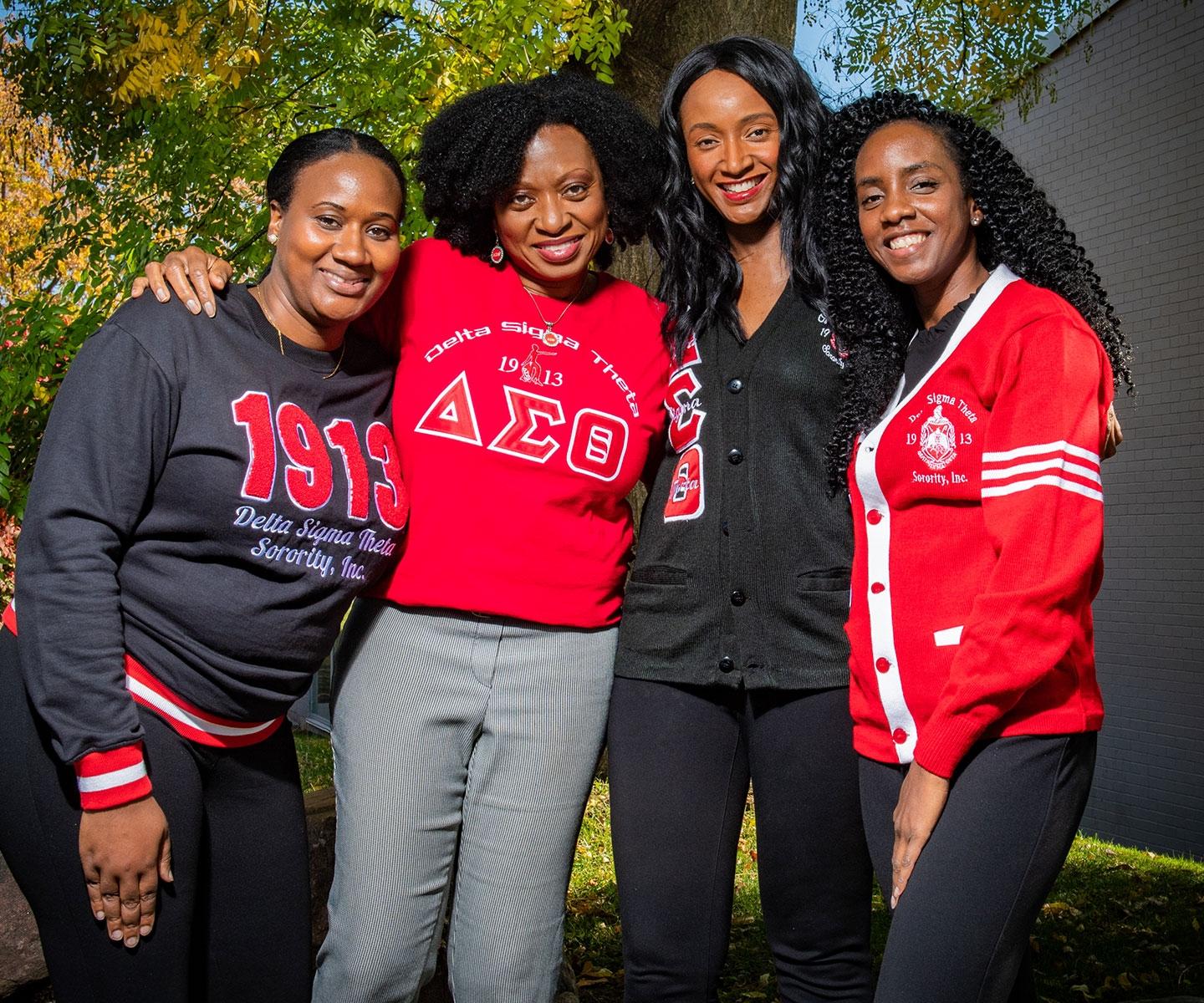 Four members of the Toronto chapter of Delta Sigma Theta Sorority, Inc., together outdoors in sorority clothing