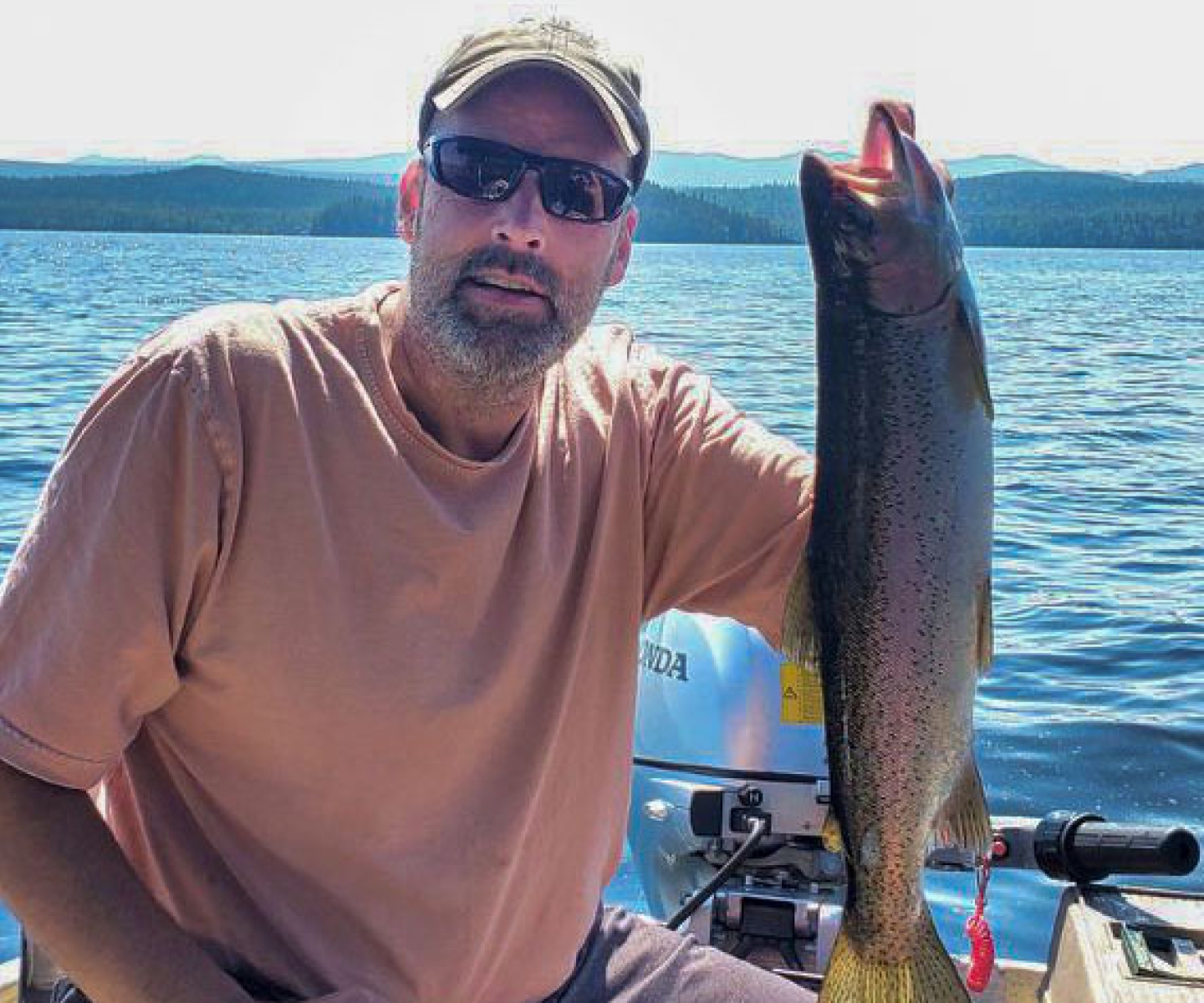 Leukemia survivor and blood recipient holding a fish