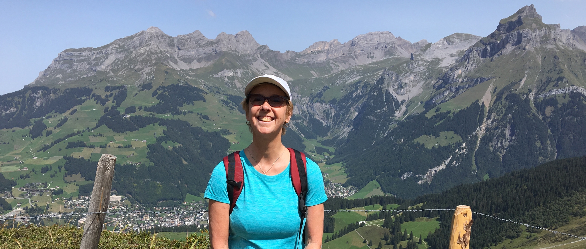 Margaret Lynch, who had a bone marrow transplant about 33 years ago, sits on a rock in front of The Alps in Switzerland.