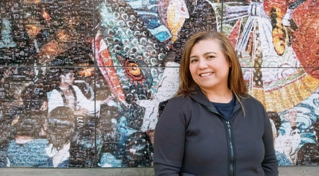 Lilet Raffiñan, a Canadian of Asian heritage who recruits donors for Canadian Blood Services, stands in front of a colourful mural.