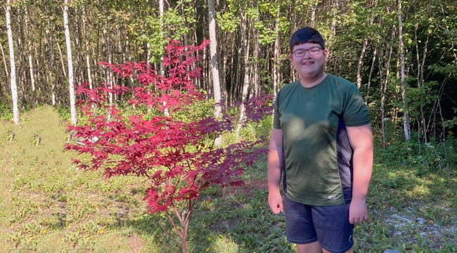 A childhood cancer survivor stands in his yard at the start of the school year 