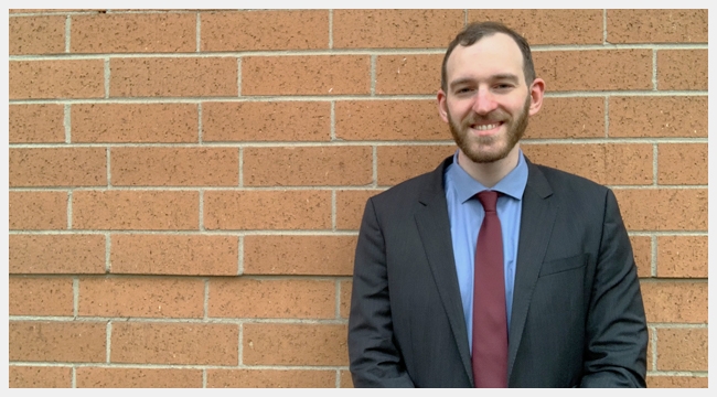 Dr. Warren Fingrut, who founded Stem Cell Club to recruit donors to Canadian Blood Services Stem Cell Registry and increase diversity of prospective donors, smiles while posing in front of a stone wall. 